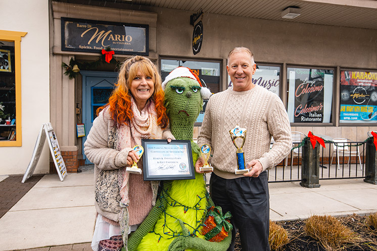 Mayor Don Walters presents Cindy Michael, owner of Downtown Cuyahoga Falls business Harps & Thistles Yarn & Gift Emporium, with 2020 Parking Meters on Parade awards for Best Decoration Business Citywide, Best Decoration Downtown Business, and Best Decoration Overall, for the Grinch.
